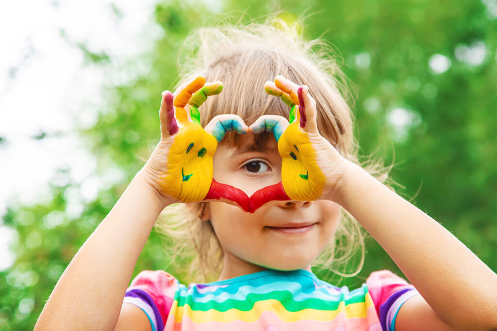 Barn med färg på händerna som formar ett hjärta