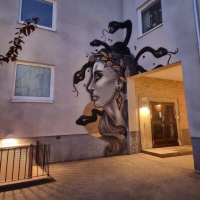 Muralmålning Medusas huvud med ormar runt på husfasad