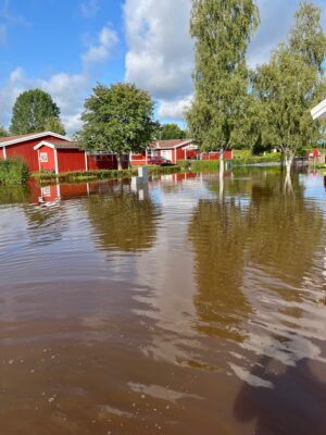 Gillstad översvämmad gräsmatta framför parhus