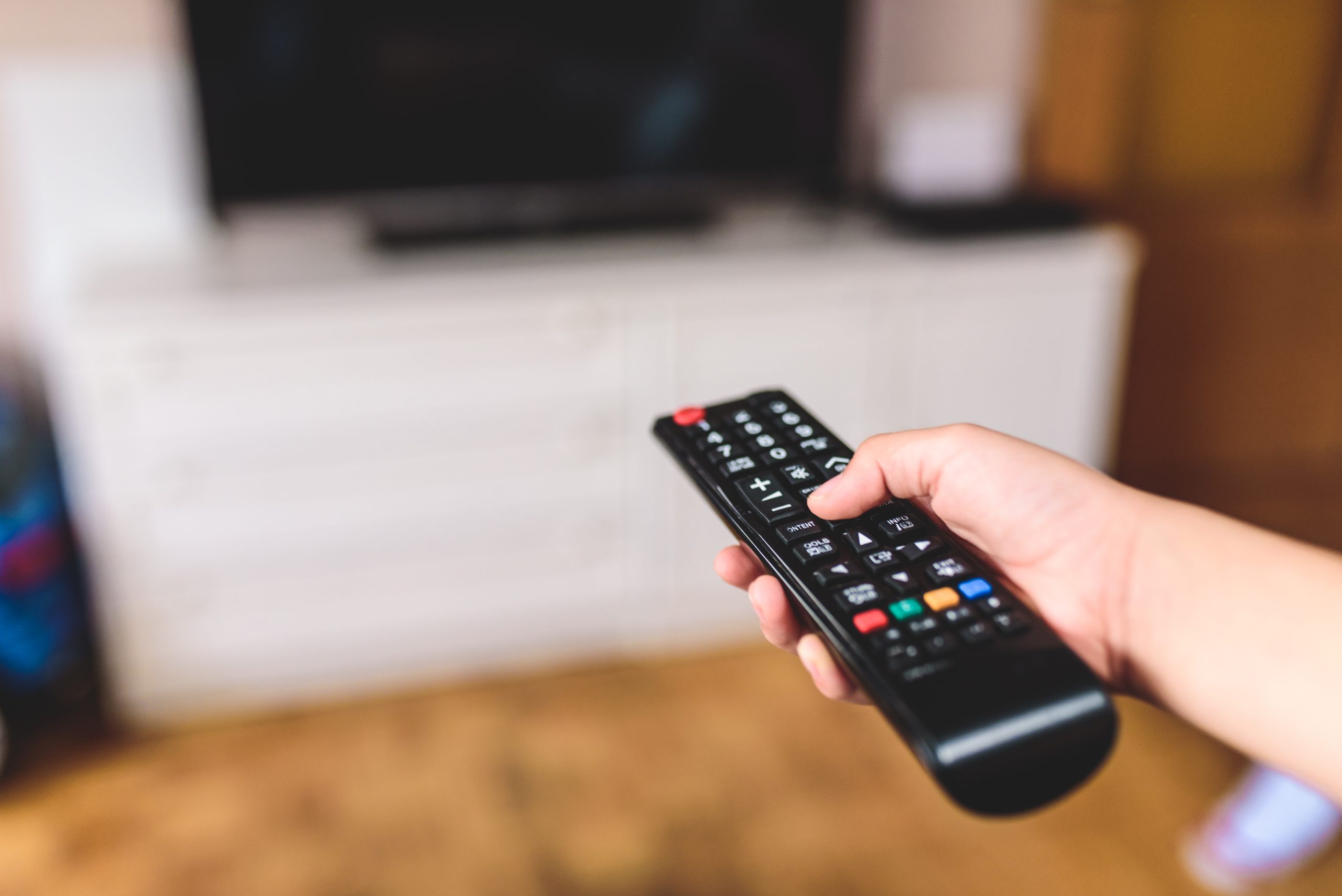 Hand med tv kontroll.